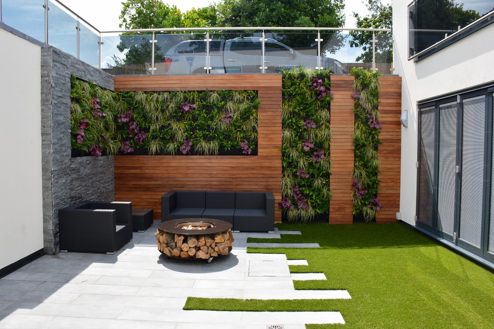 This is an example of a medium sized contemporary courtyard full sun garden in London with a living wall.