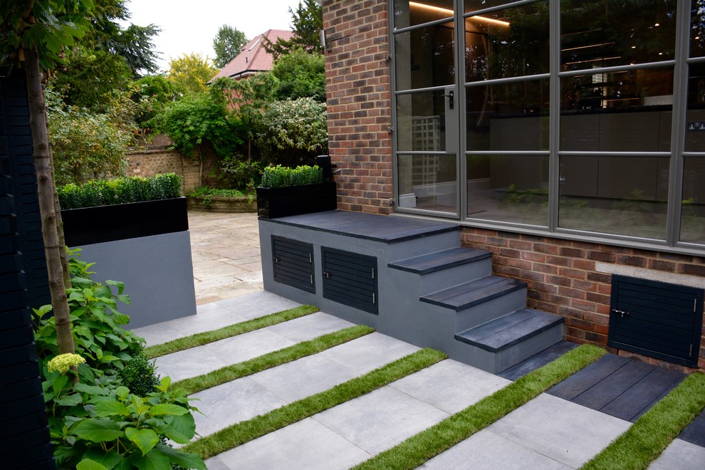 Inspiration for a small contemporary courtyard partial sun garden in London with concrete paving.