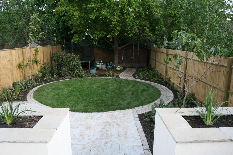 This is an example of a medium sized contemporary back partial sun garden in Other with natural stone paving.