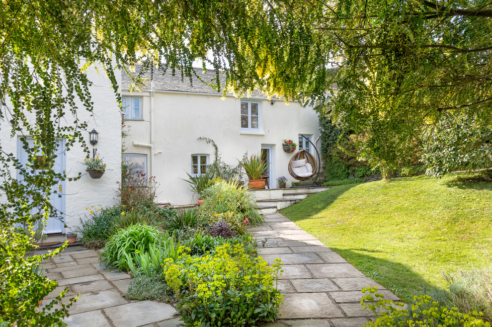 Großer Landhausstil Garten hinter dem Haus mit Natursteinplatten in Devon