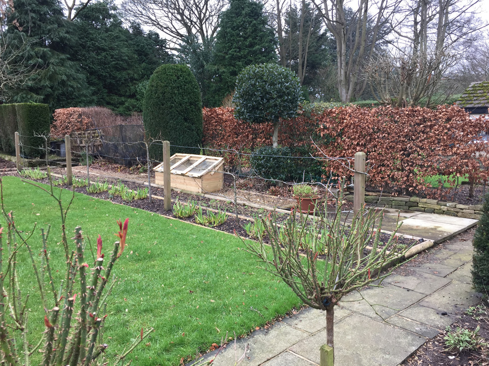Foto de jardín clásico en invierno en patio trasero con jardín francés, huerto, exposición parcial al sol y adoquines de piedra natural