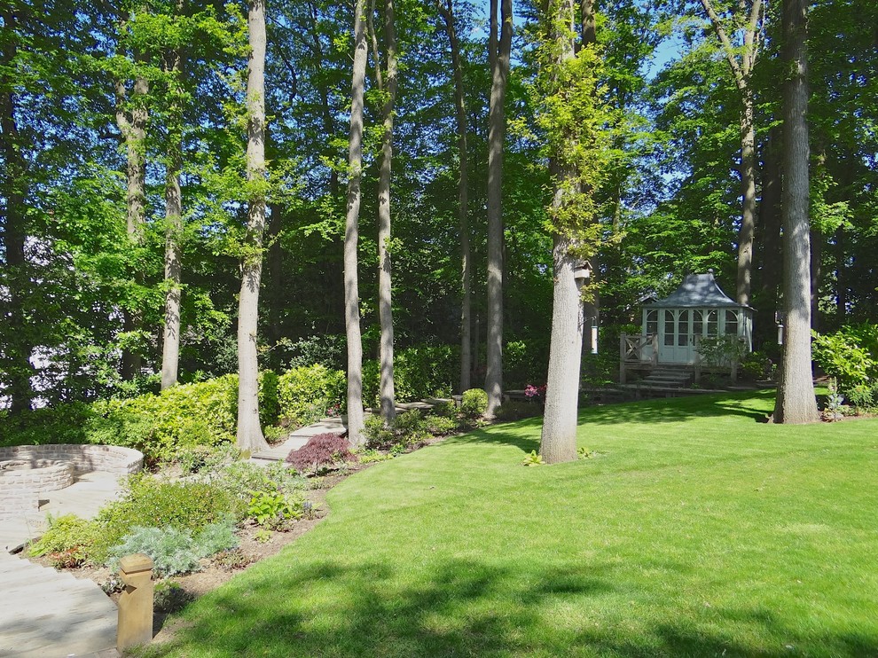 Cette image montre un grand jardin arrière rustique avec un foyer extérieur, une exposition partiellement ombragée et une terrasse en bois.