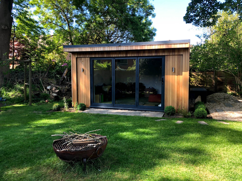 Imagen de jardín de estilo de casa de campo de tamaño medio en verano en patio trasero con exposición parcial al sol y adoquines de piedra natural