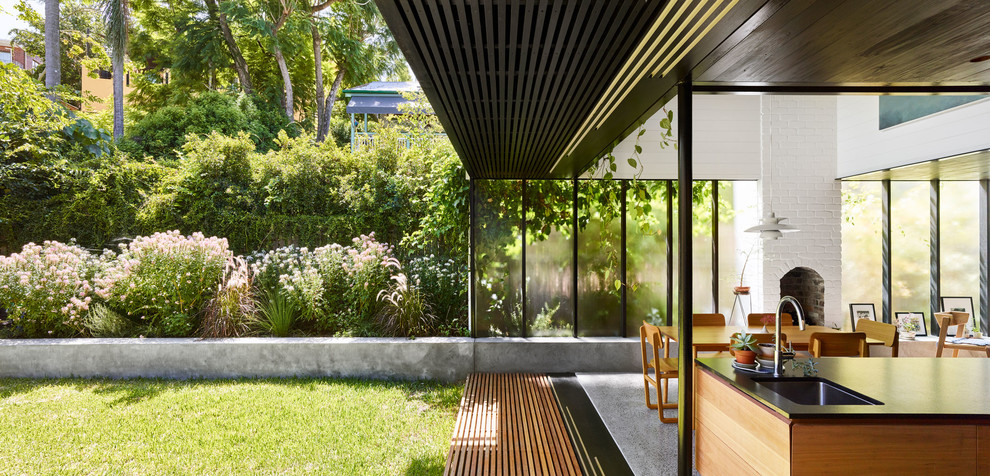 Mittelgroßer Moderner Garten hinter dem Haus, im Sommer mit Dielen und direkter Sonneneinstrahlung in Brisbane