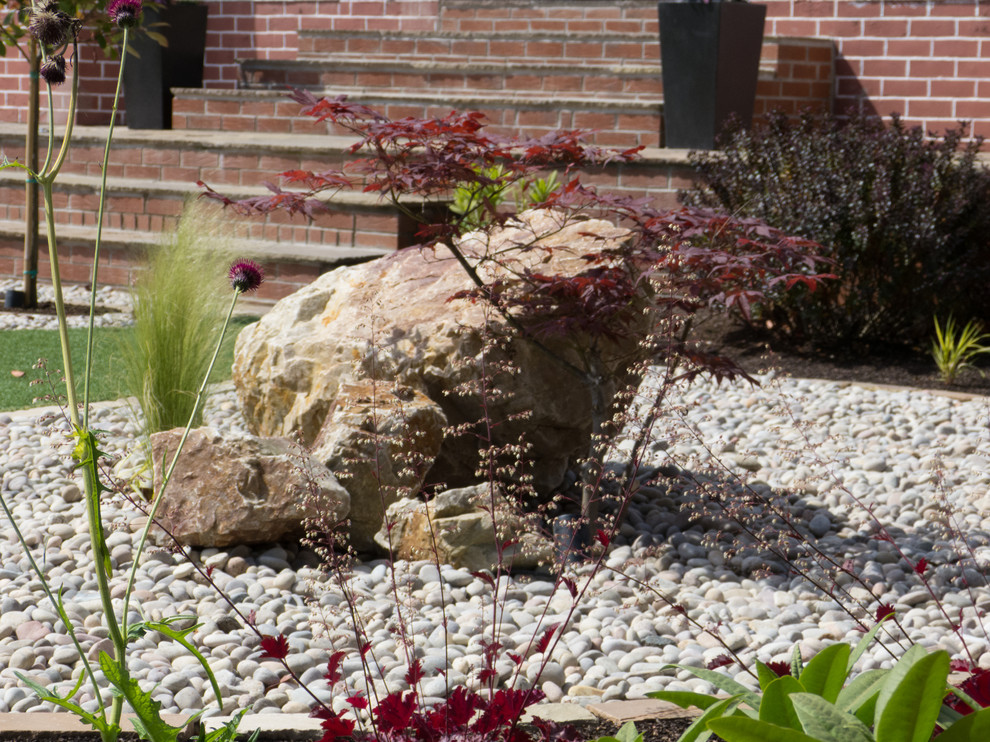 Photo of a medium sized world-inspired front formal full sun garden for summer in Glasgow with gravel.