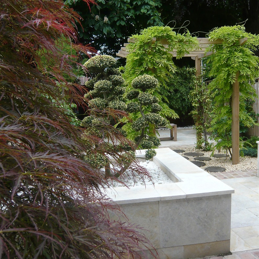 Small contemporary garden in Oxfordshire with an outdoor sport court and natural stone paving.
