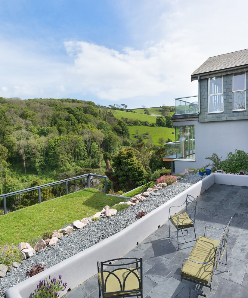 Inspiration for a large contemporary back full sun garden in Devon with natural stone paving.