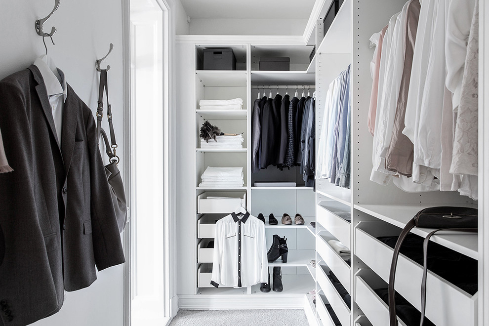 Inspiration for a medium sized scandinavian gender neutral walk-in wardrobe in Gothenburg with open cabinets, white cabinets and carpet.