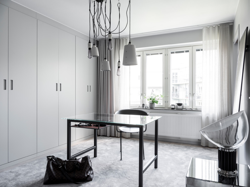 Geräumiger Moderner Begehbarer Kleiderschrank mit flächenbündigen Schrankfronten, grauen Schränken, Teppichboden und grauem Boden in Stockholm