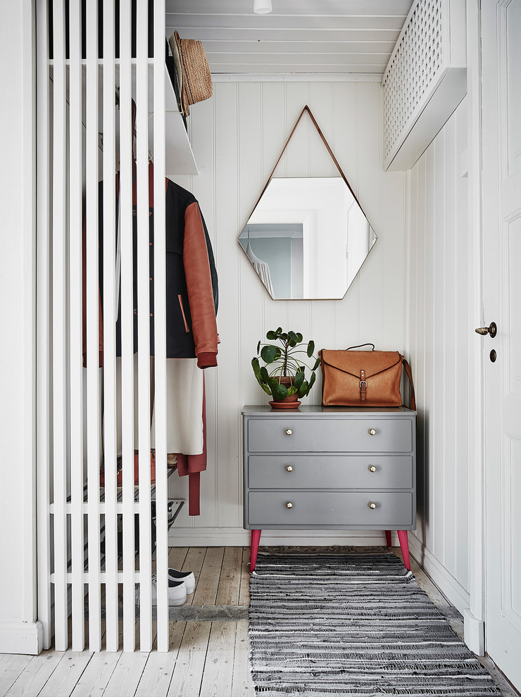 Стильный дизайн: гардеробная в скандинавском стиле с деревянным полом и белым полом - последний тренд