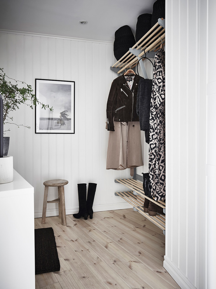 Inspiration for a scandinavian walk-in wardrobe for women in Gothenburg with light hardwood flooring and beige floors.
