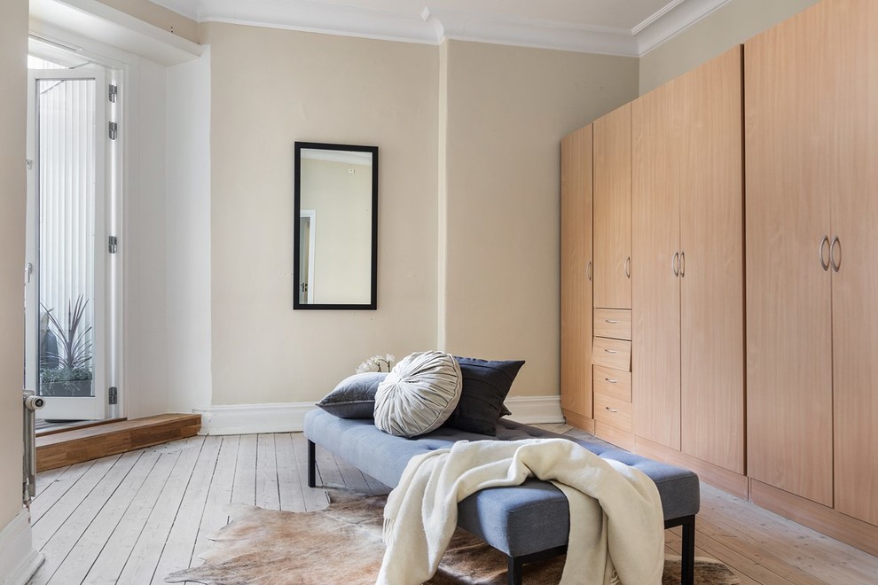 Idee per uno spazio per vestirsi unisex scandinavo con ante lisce, ante in legno chiaro, pavimento in bambù e pavimento beige