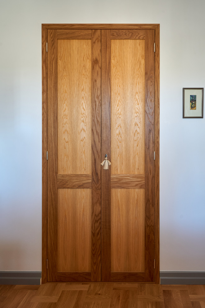 Modelo de armario vestidor unisex retro pequeño con armarios abiertos, puertas de armario de madera oscura y suelo de madera en tonos medios