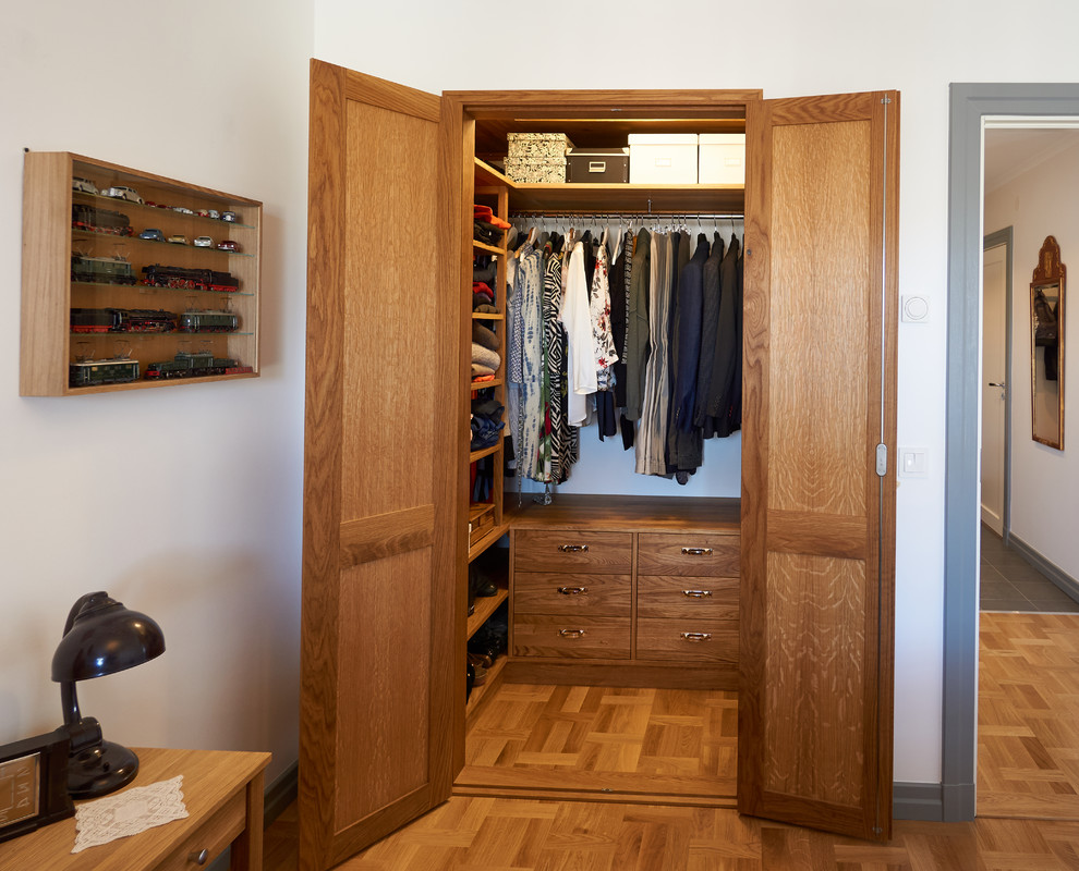 Kleiner, Neutraler Retro Begehbarer Kleiderschrank mit offenen Schränken, hellbraunen Holzschränken und braunem Holzboden in Stockholm