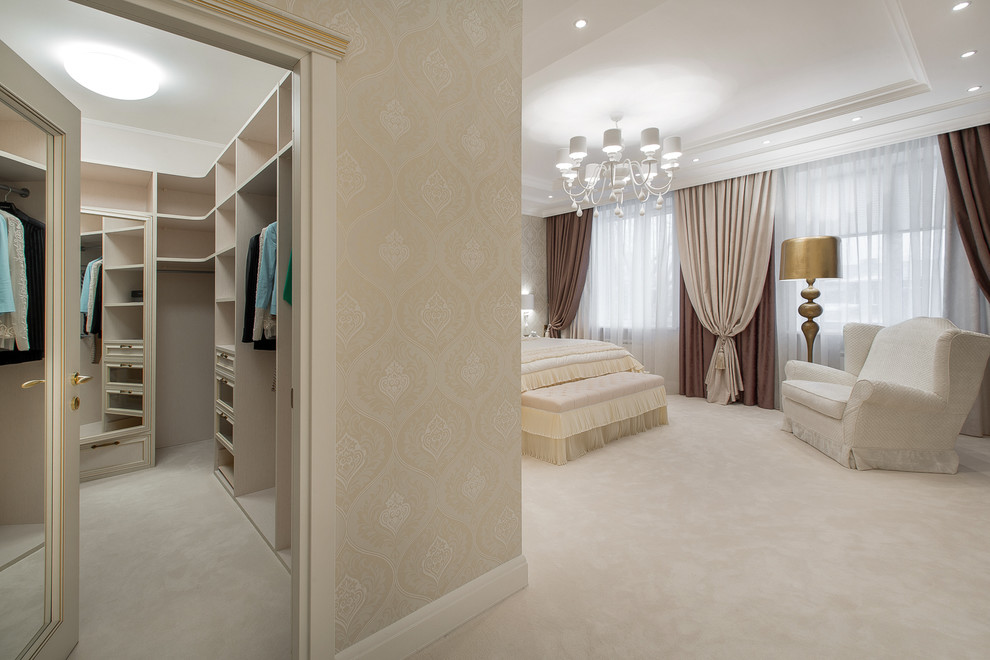 На фото: гардеробная комната в классическом стиле с бежевыми фасадами и ковровым покрытием с