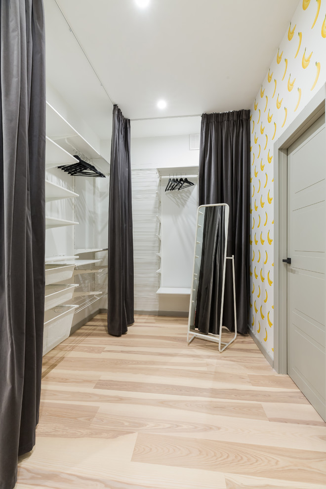 Modern inredning av ett mellanstort walk-in-closet för könsneutrala, med ljust trägolv, öppna hyllor och beiget golv