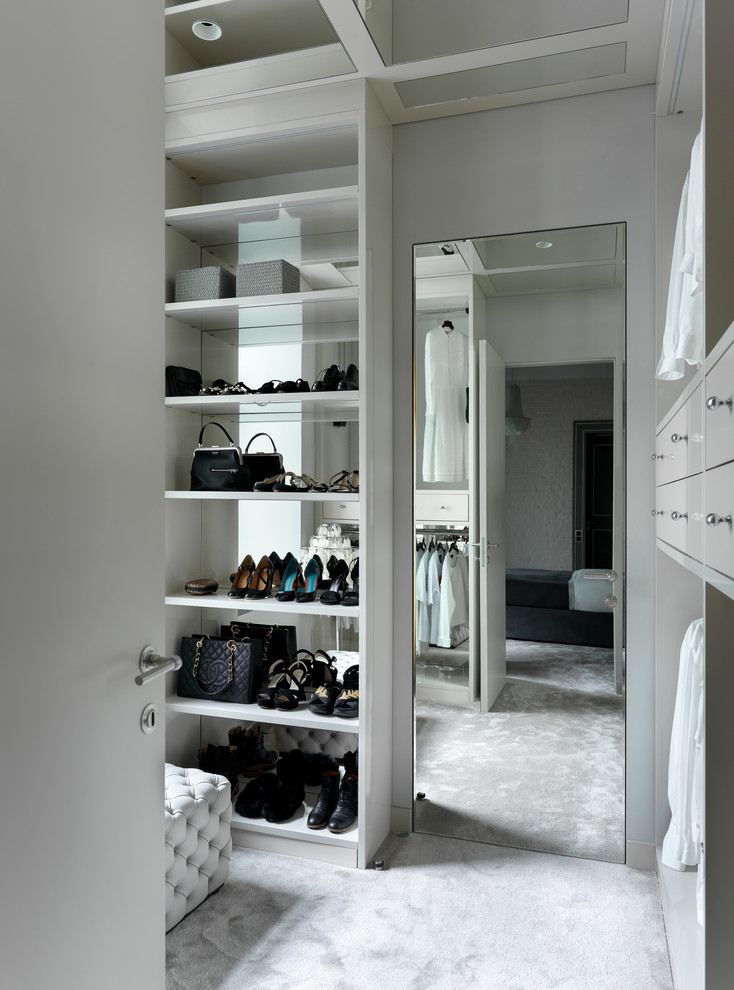Ejemplo de vestidor de mujer actual con moqueta, armarios abiertos, puertas de armario grises y suelo gris