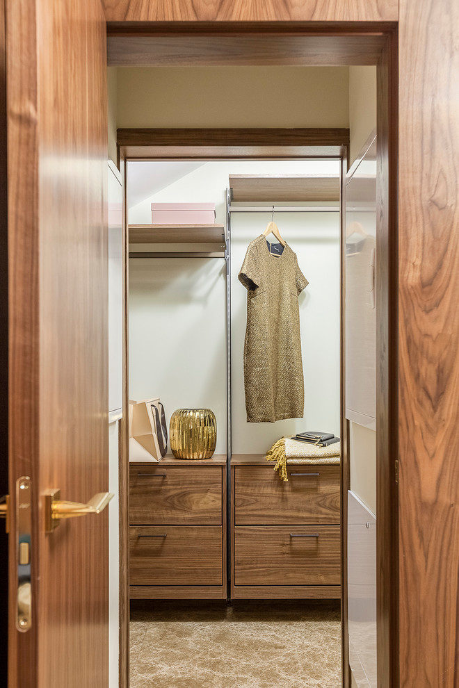 На фото: гардеробная комната унисекс в стиле неоклассика (современная классика) с темными деревянными фасадами, мраморным полом, коричневым полом и плоскими фасадами
