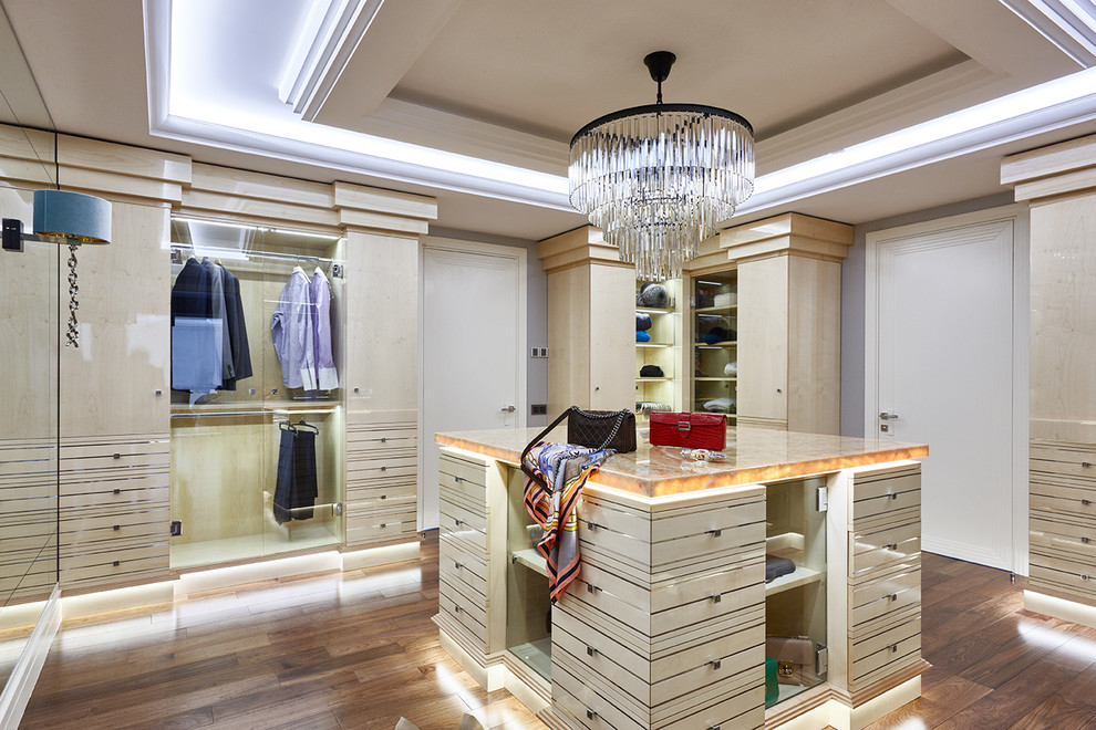 Example of a trendy gender-neutral medium tone wood floor and beige floor dressing room design in Moscow with beige cabinets