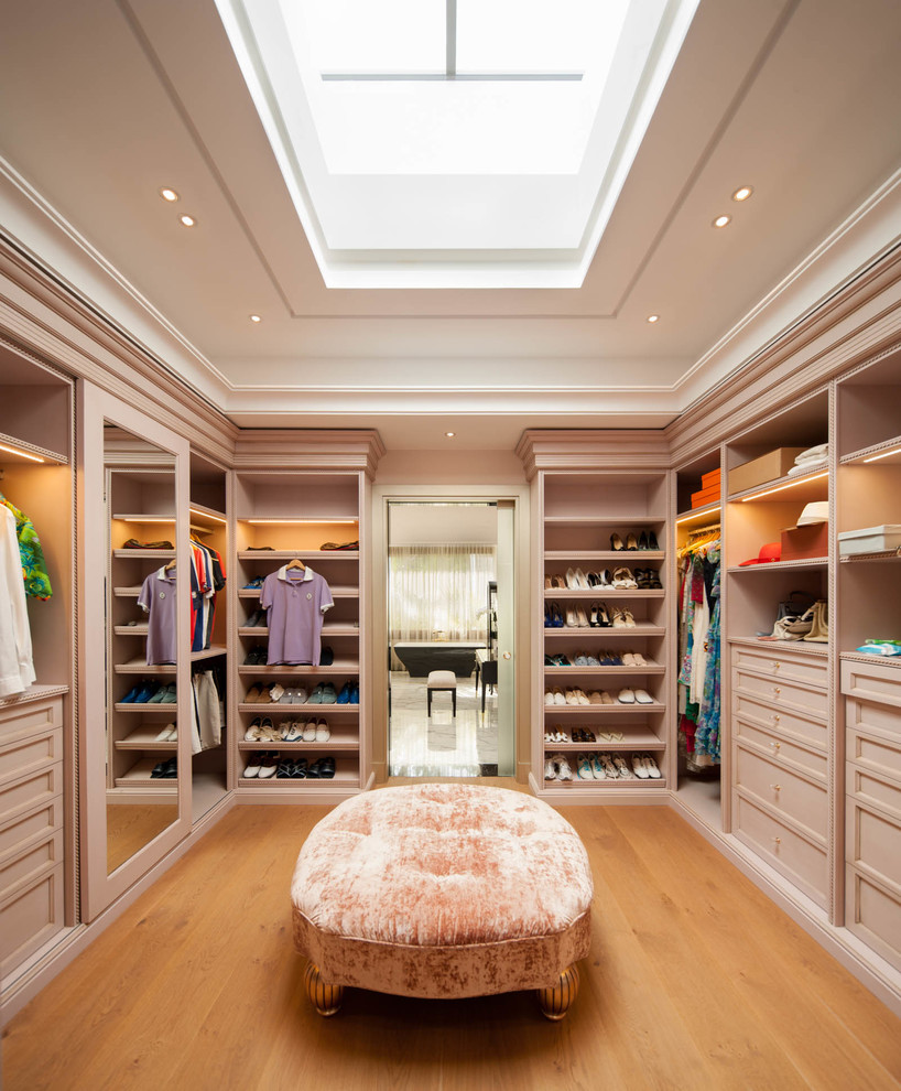 Large trendy gender-neutral medium tone wood floor walk-in closet photo in Moscow with beige cabinets and recessed-panel cabinets