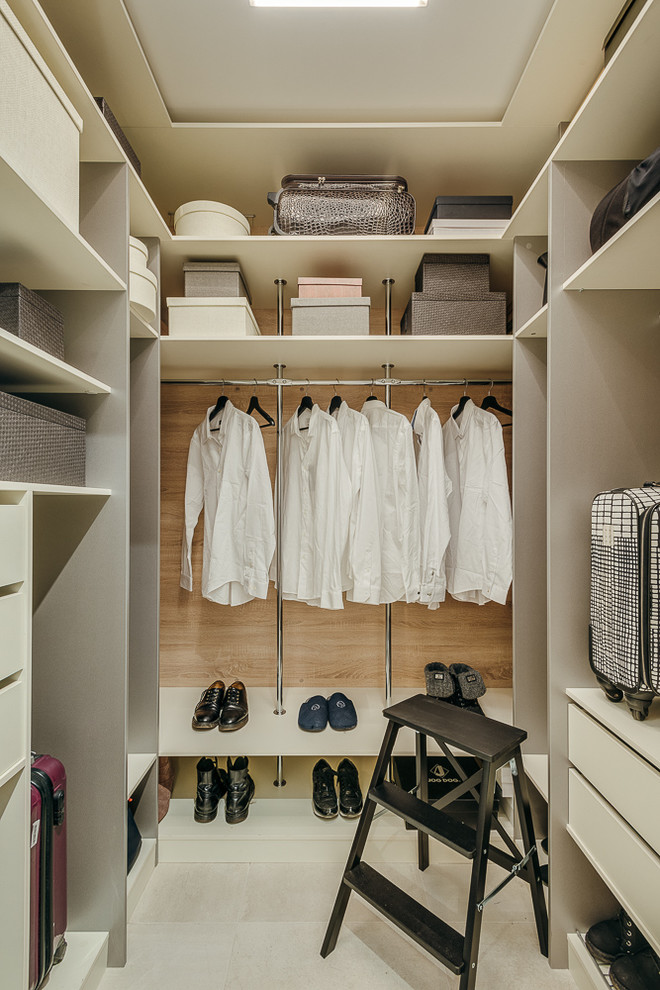 Ejemplo de armario vestidor urbano con armarios abiertos, puertas de armario blancas y suelo gris