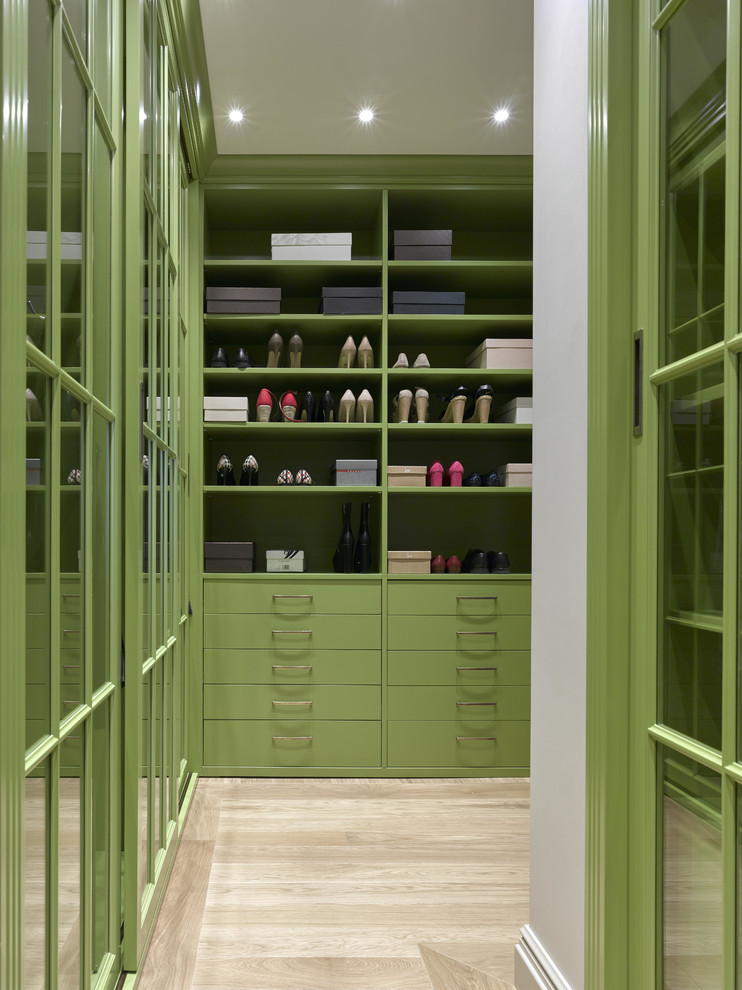 Ejemplo de armario vestidor unisex tradicional renovado de tamaño medio con puertas de armario verdes, suelo de madera clara y suelo beige