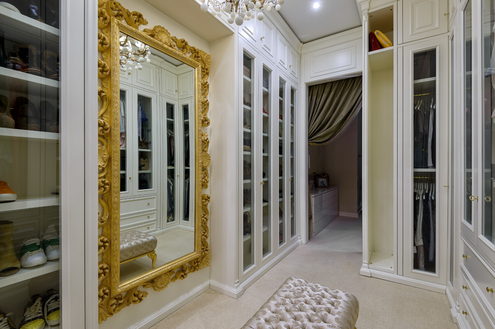 Cette photo montre un dressing room chic neutre avec un placard à porte vitrée, des portes de placard blanches et moquette.