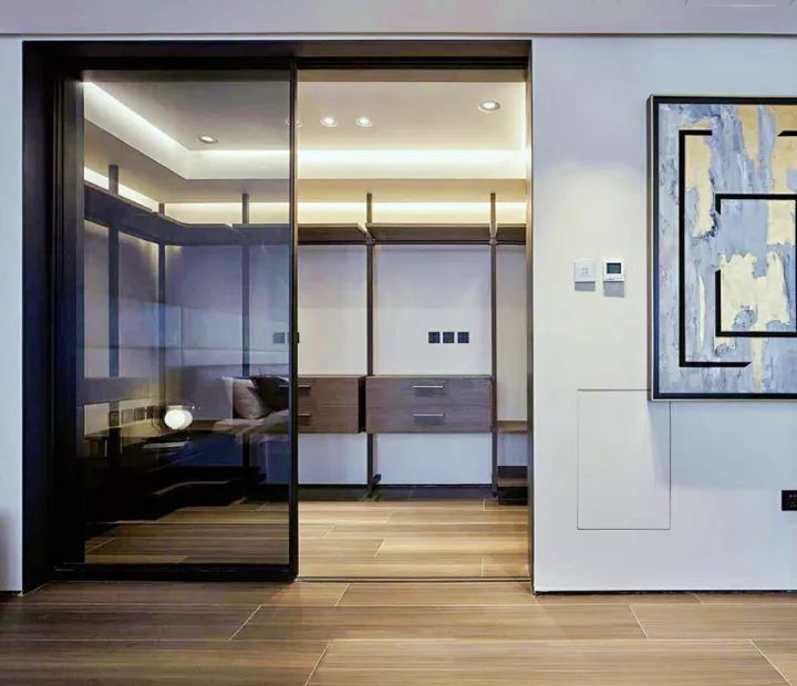 This is an example of a large contemporary gender neutral walk-in wardrobe in Moscow with glass-front cabinets, laminate floors and beige floors.
