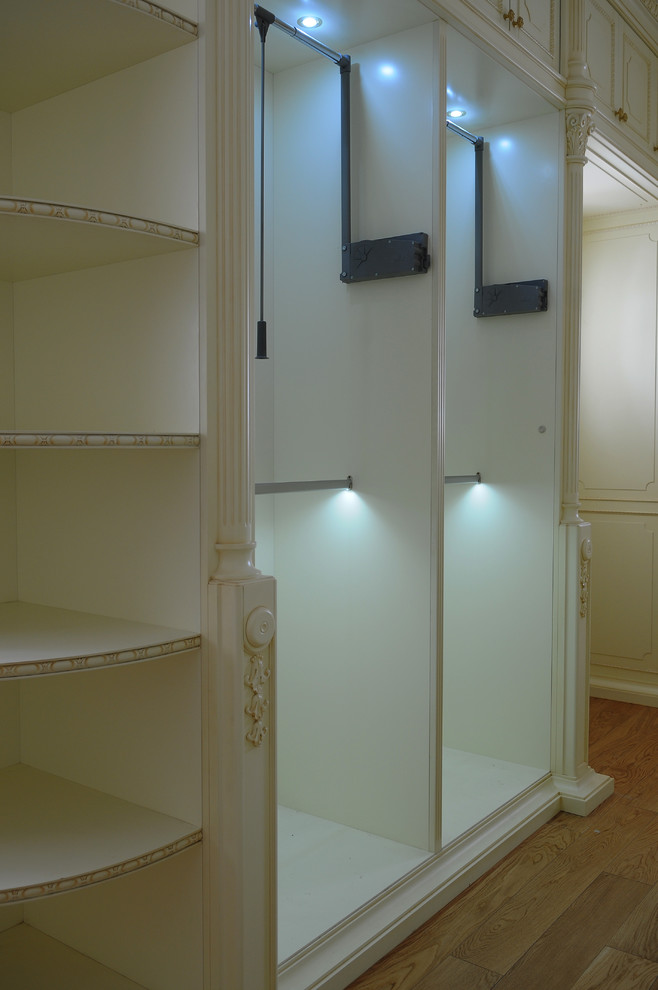 Стильный дизайн: большая гардеробная комната унисекс в классическом стиле с фасадами с выступающей филенкой и белыми фасадами - последний тренд