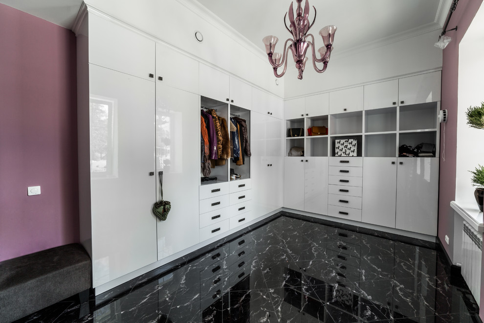 Diseño de armario vestidor unisex contemporáneo de tamaño medio con armarios con paneles con relieve, puertas de armario blancas, suelo de mármol y suelo negro