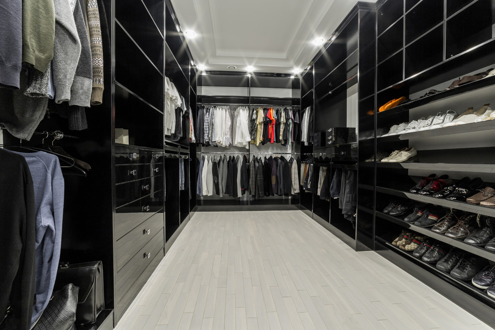 Imagen de armario vestidor unisex tradicional renovado de tamaño medio con armarios con paneles con relieve, suelo de mármol, puertas de armario negras y suelo gris