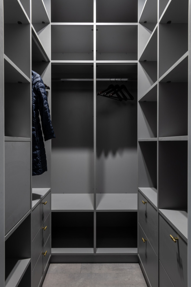 Modelo de armario y vestidor actual grande con suelo laminado y suelo gris