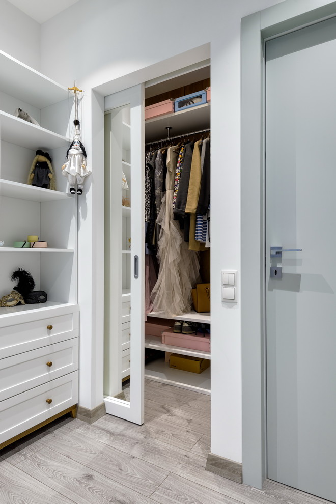 Inspiration for a contemporary gender-neutral light wood floor reach-in closet remodel in Moscow