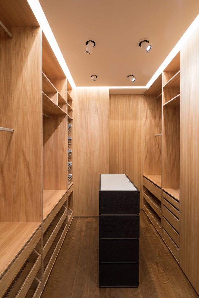 Design ideas for a small contemporary gender neutral dressing room in Moscow with flat-panel cabinets, medium wood cabinets, medium hardwood flooring and brown floors.