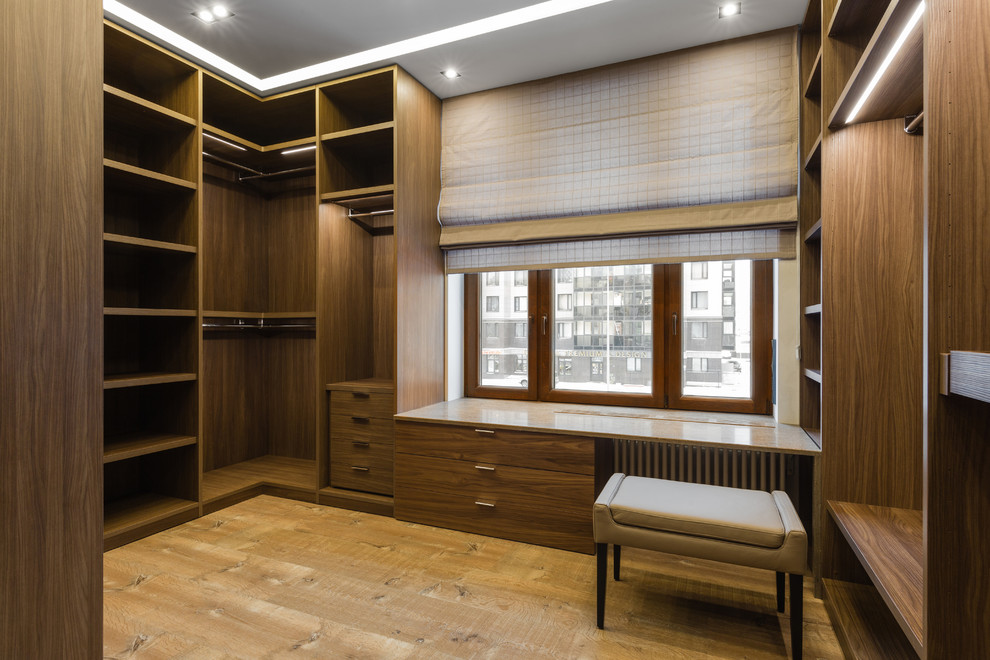 Immagine di uno spazio per vestirsi unisex minimal con ante in legno bruno, pavimento marrone, nessun'anta e pavimento in legno massello medio