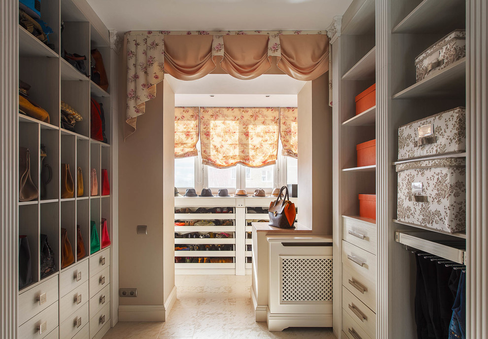 This is an example of a traditional gender neutral dressing room in Moscow with open cabinets and white cabinets.