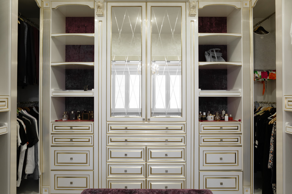 Ejemplo de armario y vestidor unisex tradicional pequeño con armarios con paneles con relieve, puertas de armario de madera clara y suelo beige