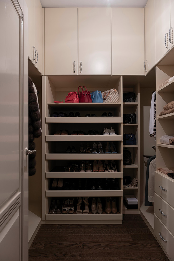Small transitional gender-neutral medium tone wood floor and brown floor walk-in closet photo in Other with flat-panel cabinets and beige cabinets