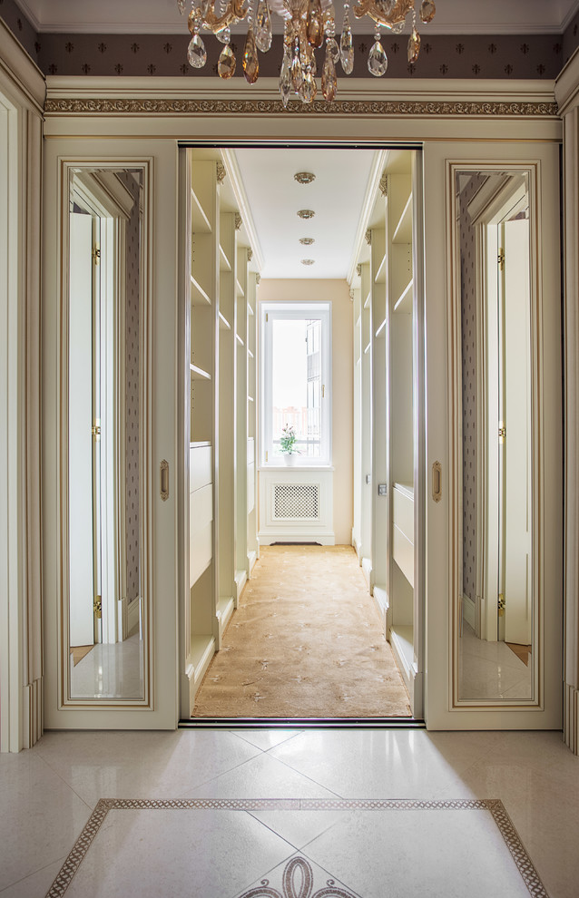 Photo of a traditional walk-in wardrobe in Moscow with flat-panel cabinets and white cabinets.
