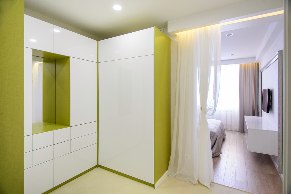 Свежая идея для дизайна: гардеробная комната унисекс в современном стиле с плоскими фасадами, белыми фасадами и ковровым покрытием - отличное фото интерьера