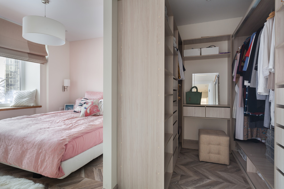 This is an example of a small traditional walk-in wardrobe for women in Moscow with open cabinets, beige cabinets, laminate floors and brown floors.