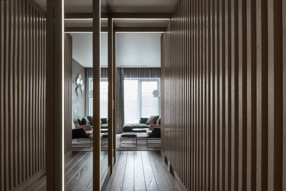 Стильный дизайн: гардеробная комната среднего размера в современном стиле с паркетным полом среднего тона и серым полом - последний тренд