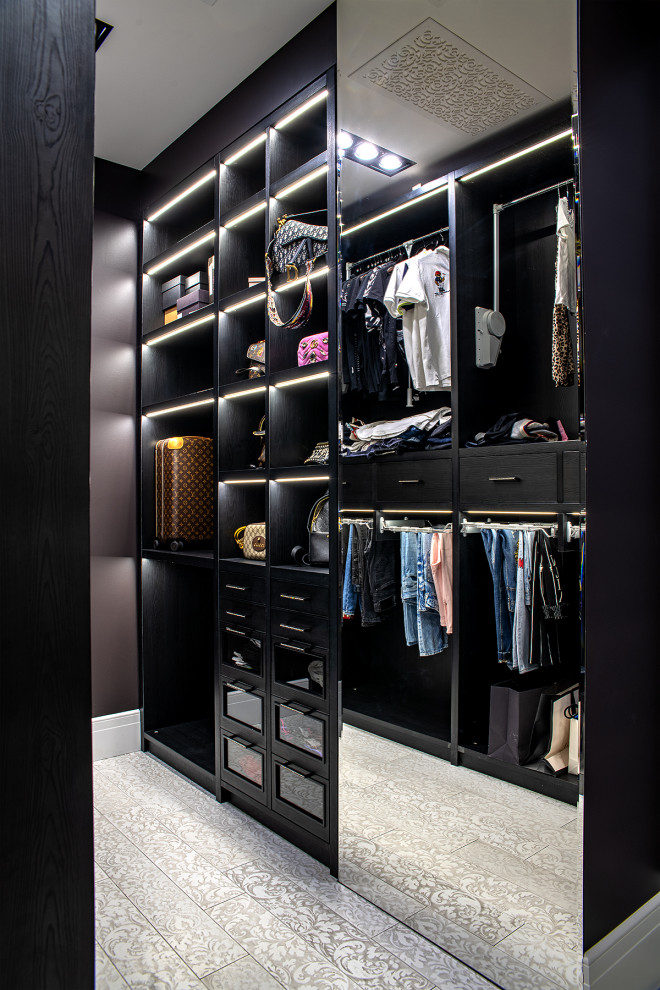 Пример оригинального дизайна: гардеробная комната в стиле неоклассика (современная классика) с черными фасадами и серым полом
