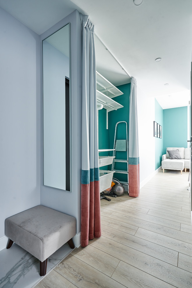 Diseño de armario vestidor escandinavo con armarios abiertos, suelo de madera clara y suelo beige
