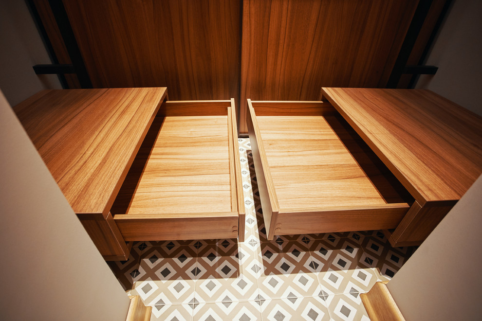 На фото: маленькая гардеробная комната в современном стиле с полом из керамической плитки для на участке и в саду с