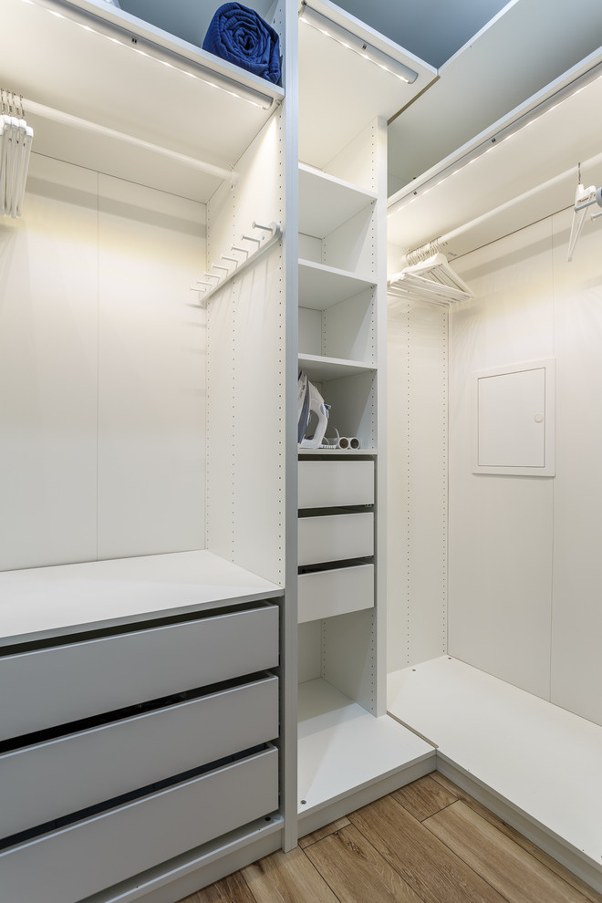 Стильный дизайн: гардеробная комната унисекс в скандинавском стиле с плоскими фасадами, серыми фасадами, коричневым полом и паркетным полом среднего тона - последний тренд