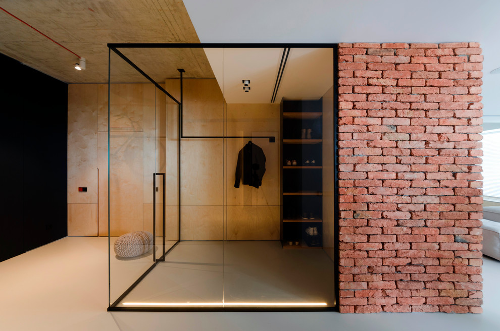 Idée de décoration pour un dressing room urbain en bois clair neutre avec un placard à porte plane et un sol gris.