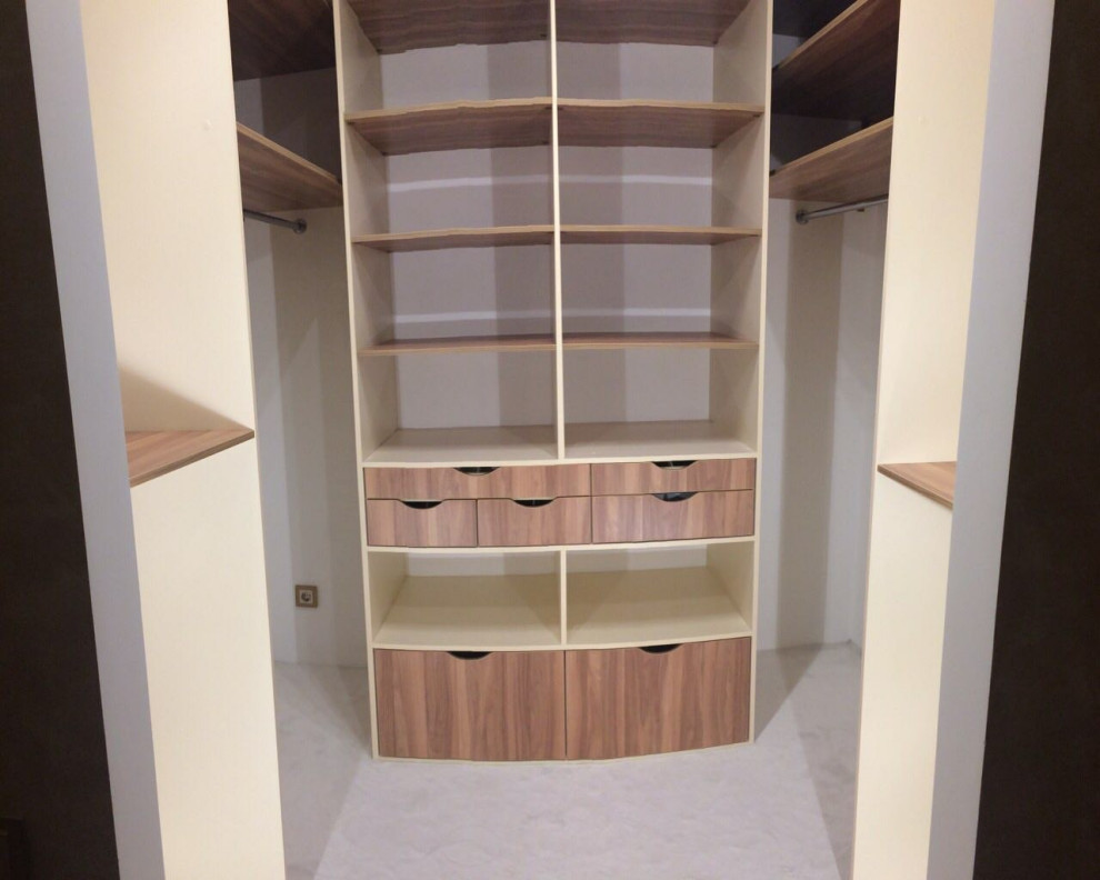 Ispirazione per una cabina armadio unisex minimal di medie dimensioni con ante lisce, ante in legno scuro, pavimento in laminato e pavimento beige