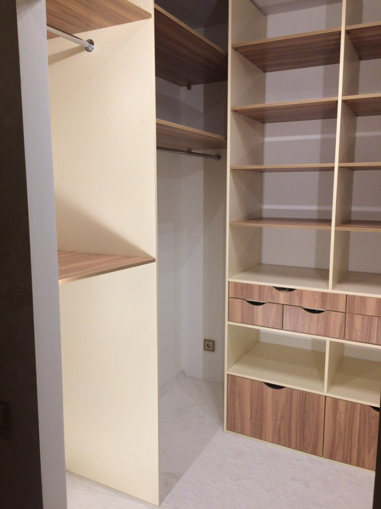 Idee per una cabina armadio unisex minimal di medie dimensioni con ante lisce, ante in legno scuro, pavimento in laminato e pavimento beige