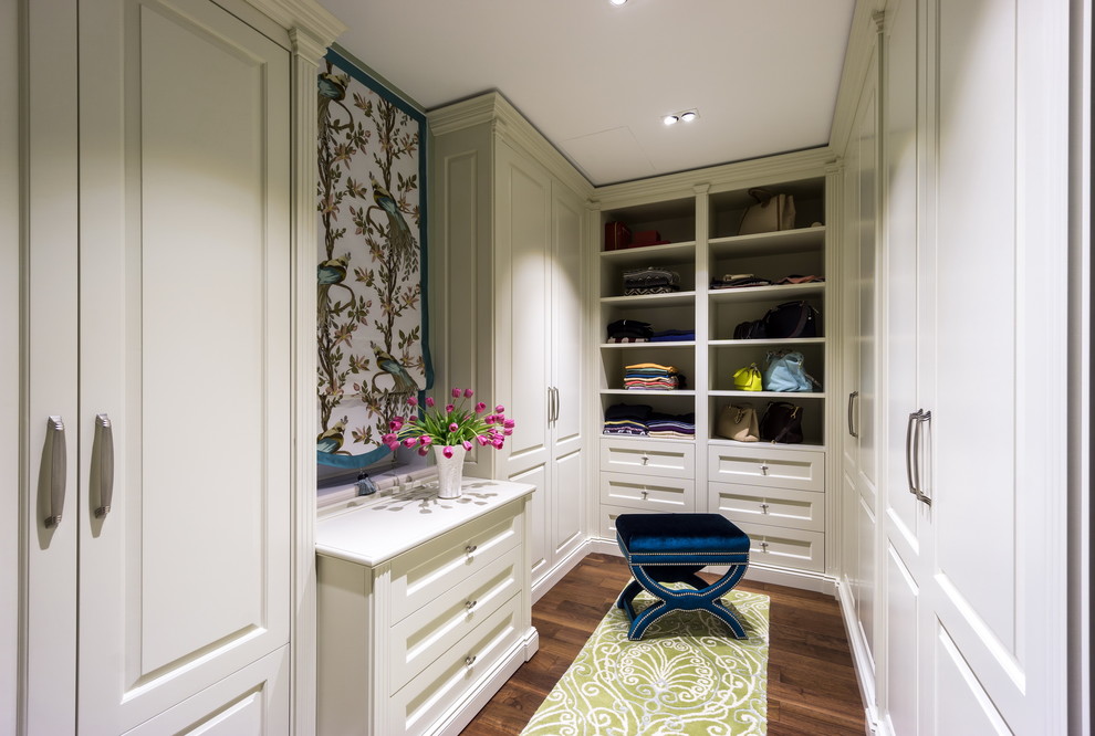 Example of a mid-sized classic gender-neutral dark wood floor and brown floor dressing room design in Moscow with white cabinets and raised-panel cabinets